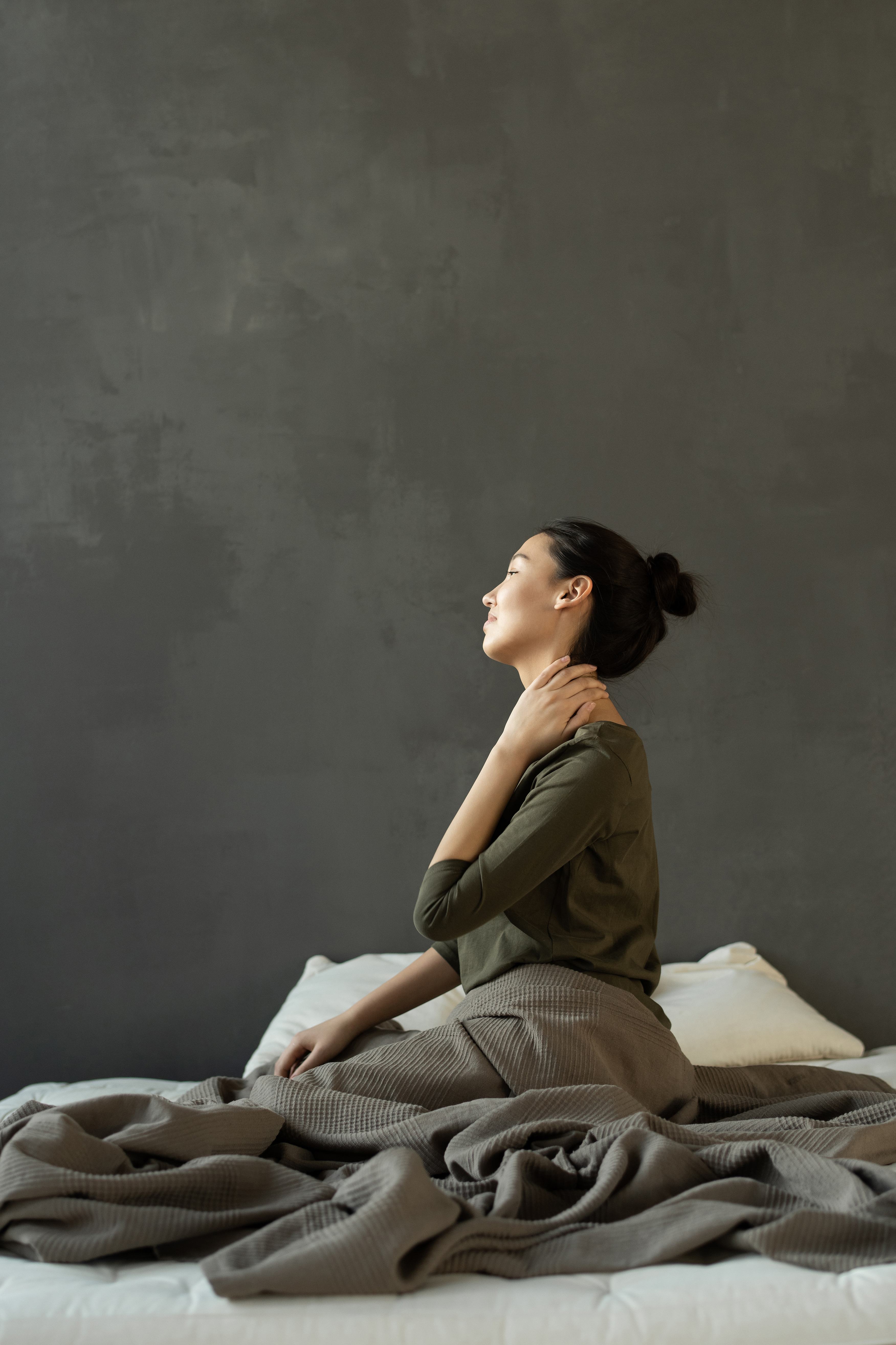 Canva - Woman in Gray Dress Sitting on Bed