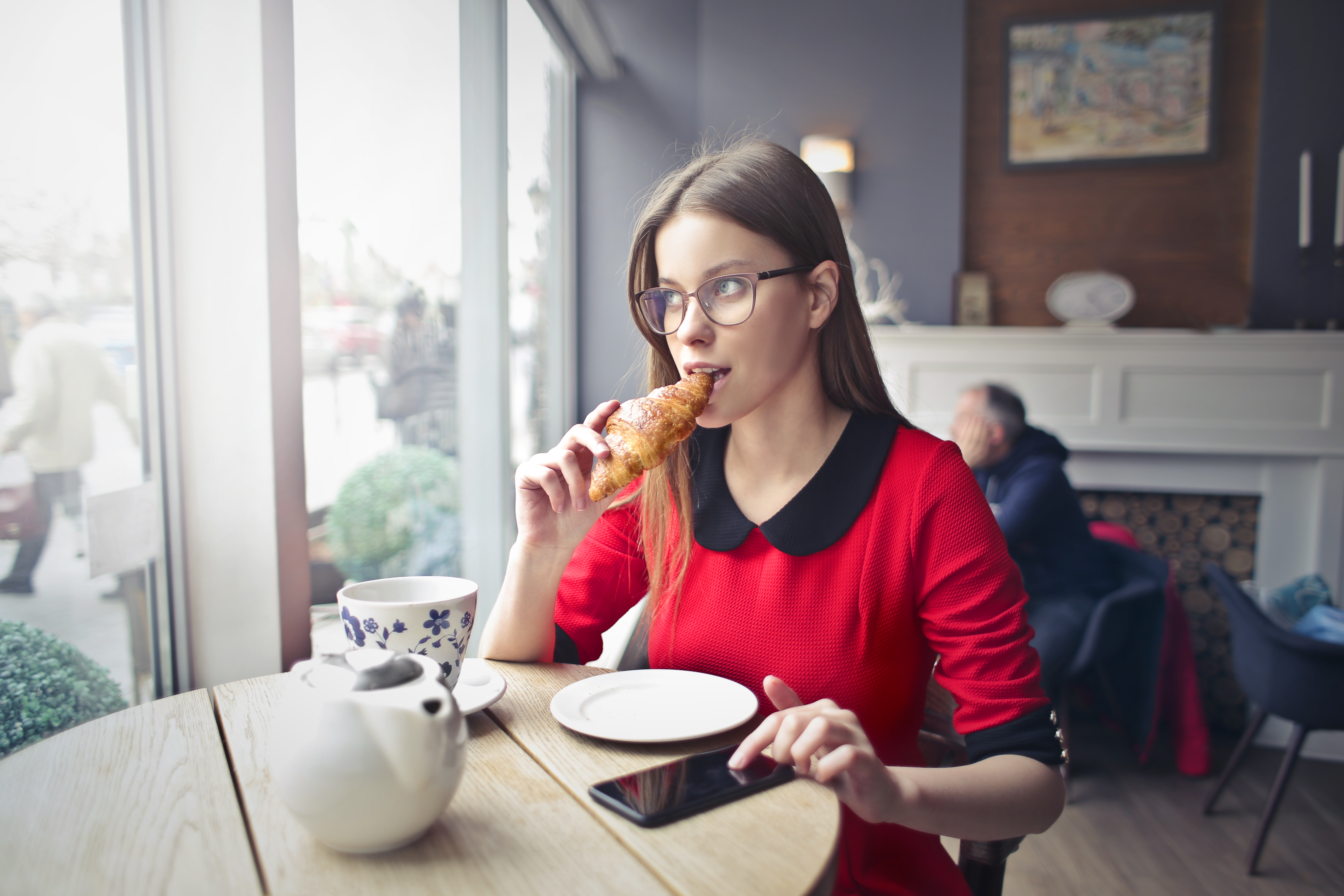 Canva - Woman Sitting on Wooden Chair Eating Bread (1)