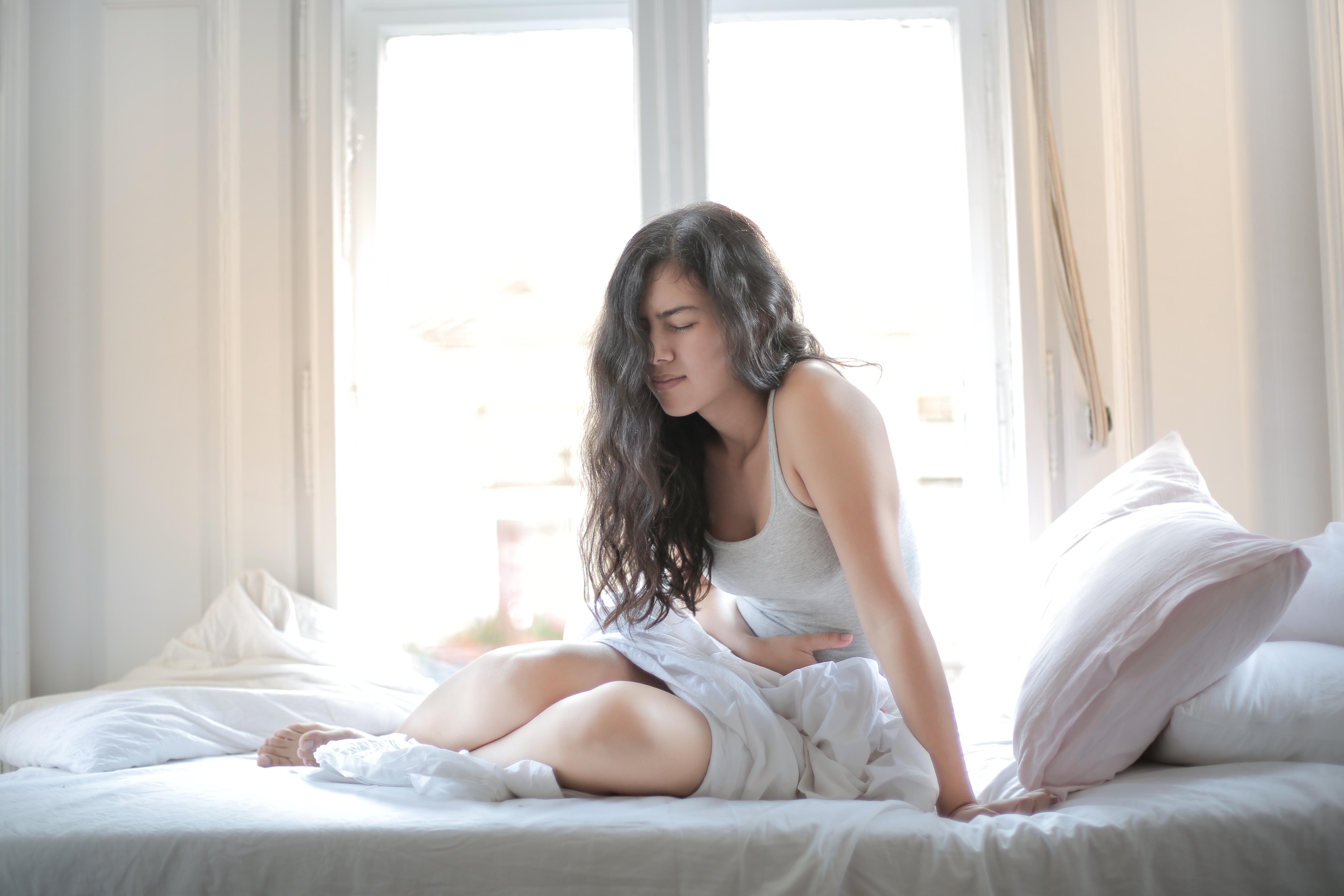 Canva - Woman in Gray Tank Top While Sitting on Bed