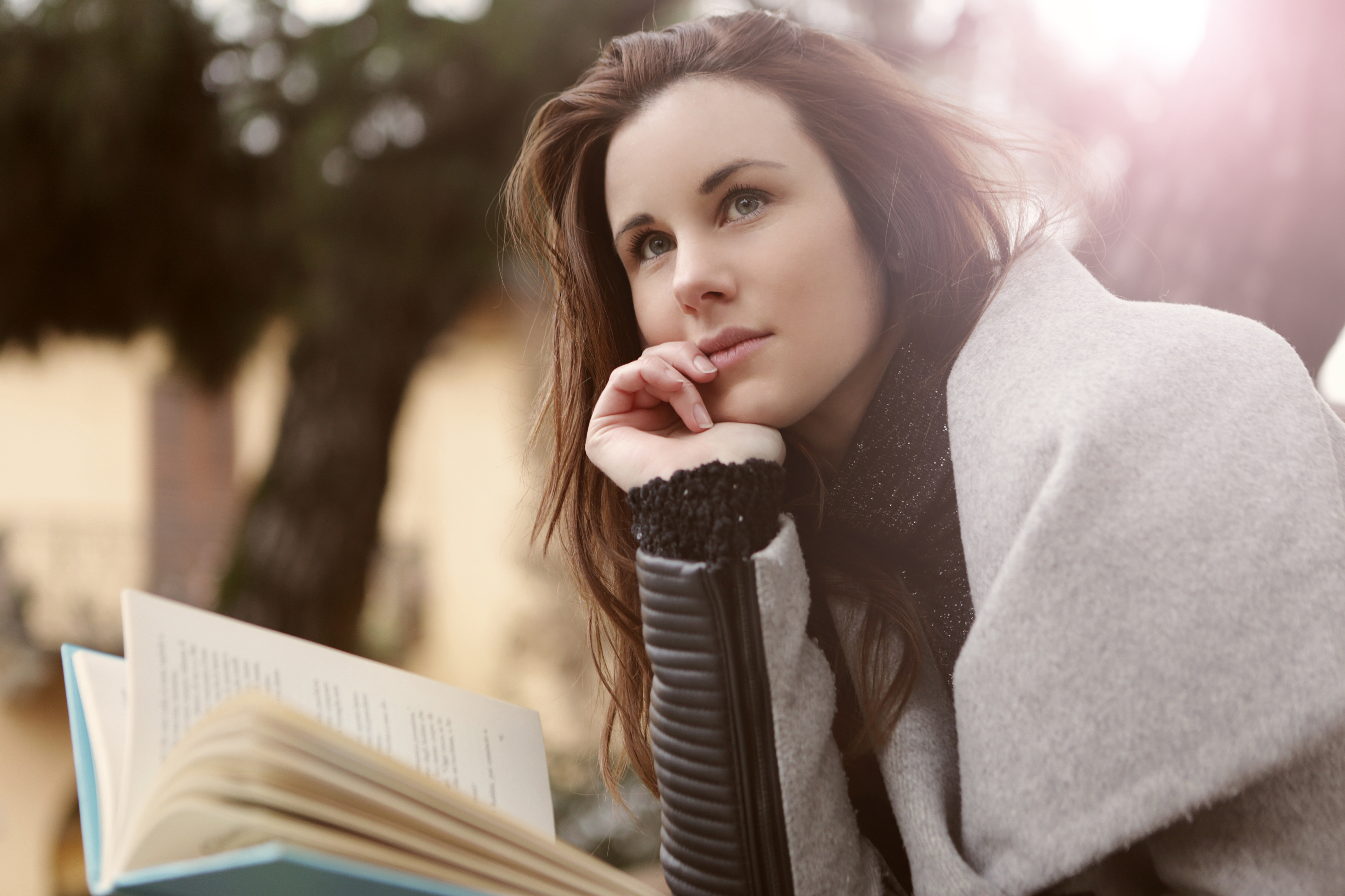 Canva - Pensive Woman in Gray Coat Holding Book